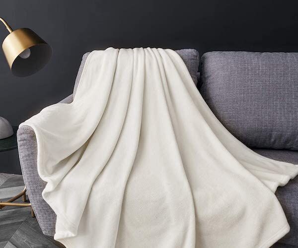 Одеяло цвета слоновой кости на диване
