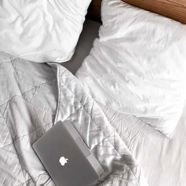 macbook on a messy bed