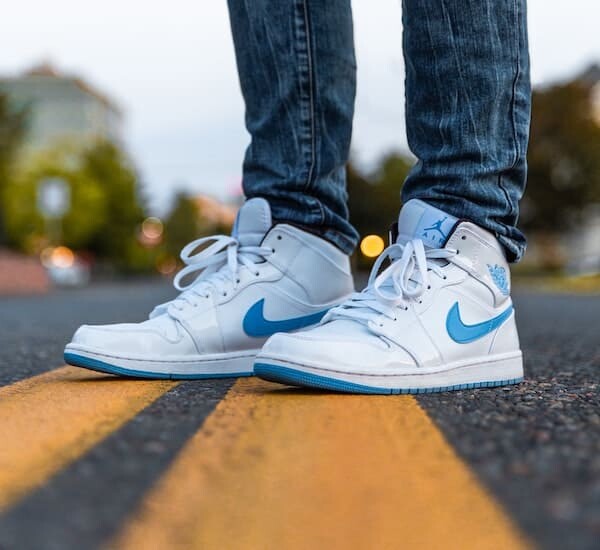 person wearing white and blue air jordan 1